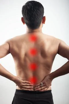 Red highlight spot on human back spinal cord signifying backache or body pain Stock Photos