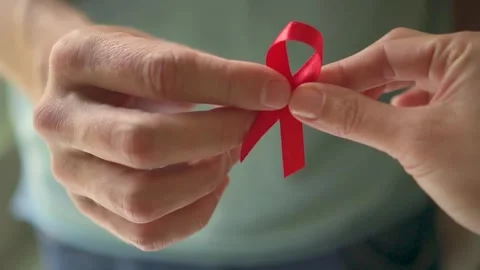 Red HIV Support Ribbon Passed Between Hands Stock Footage 317512005