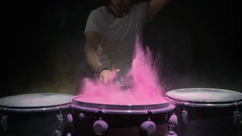 Red holi powder bounces off drum in shockwave pattern, slow motion. black Stock Footage 102736331
