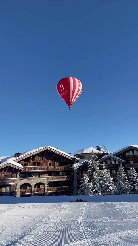 Red hot air balloon flying over ski resort in French alps Stock Footage 337060837