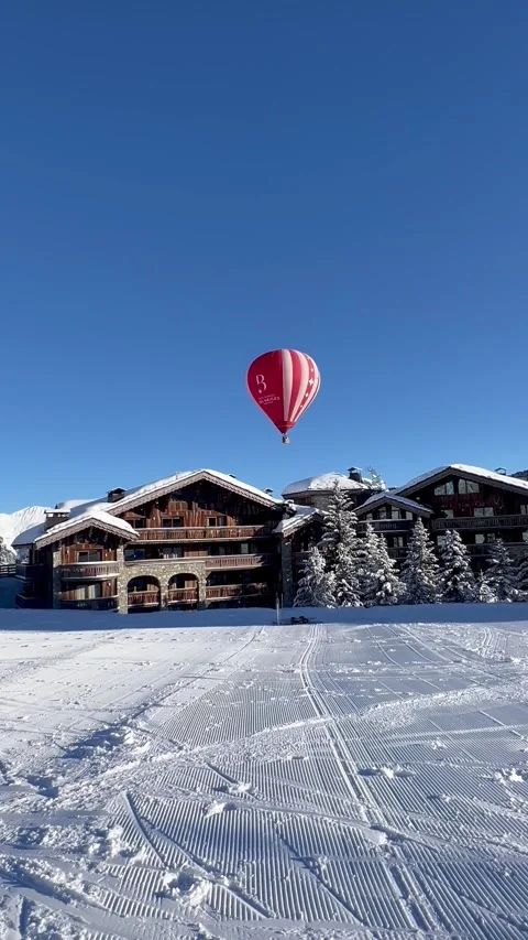 Red hot air balloon flying over ski resort in French alps Stock Footage 337061180