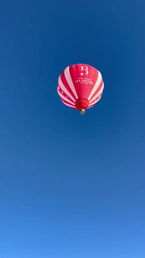 Red hot air balloon flying over ski resort in French alps Stock Footage 337061235