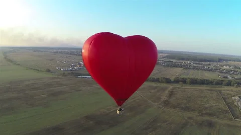 Red hot air balloon in the shape of a heart in the air. View around, aerial. 動画素材 41717678