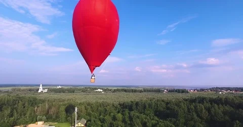 Red hot air balloon in the shape of a heart in the air. View around, aerial Video stock 71213184