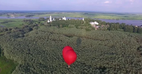 Red hot air balloon in the shape of a heart in the air. View around, aerial Video stock 71213205
