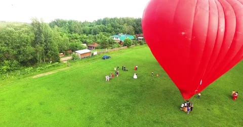 Red hot air balloon in the shape of a heart in the air. View around, aerial Video stock 71213214