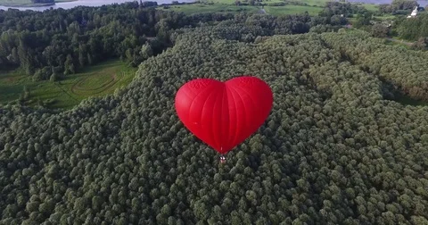 Red hot air balloon in the shape of a heart in the air. View around, aerial 動画素材 71213608