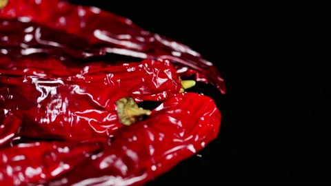 Red hot chilli pepper isolated on dark background. Red chilies is commonly used Video stock 165645795