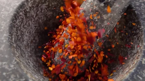 Red hot chilli peppers falling into the stone mortar in slow motion Video stock 302214764