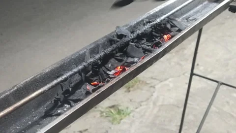 Red hot coals glowing in a special long satay grill Stock Footage 323364696