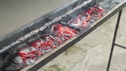 Red hot coals glowing in a special long satay grill Stock Footage 323364883