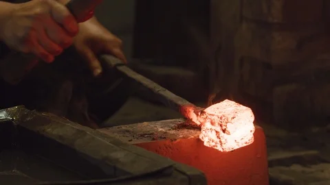 Red hot glowing ingot placed on an anvil and hit with a blacksmith's hammer. Stock Footage 125435488