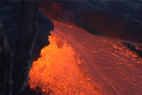 Red hot lava flows down the slopes of a volcano. Stockbeeldmateriaal 552635