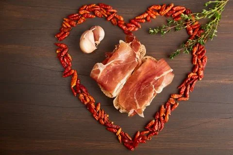 Red hot pepper is lined in the form of heart. A branch of thyme, a clove of g Stock Photos