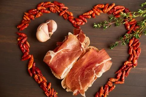 Red hot pepper is lined in the form of heart. A branch of thyme, a clove of g Stock Photos