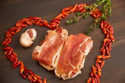Red hot pepper is lined in the form of heart. A branch of thyme, a clove of g Stock Photos