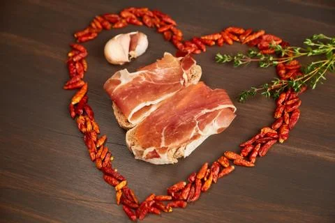 Red hot pepper is lined in the form of heart. A branch of thyme, a clove of g Stock Photos