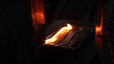 Red-hot wrench shape glowing in forging die mold inside dark industrial press Stock Footage 336681852