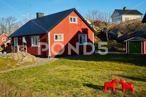 Red house at sea shore in the baltic sea in dull colors in autumn. Stock Photos