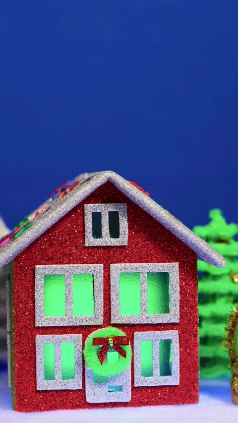 A red house surrounded on both sides by a snake statue and a snowman Stock Footage 299542424