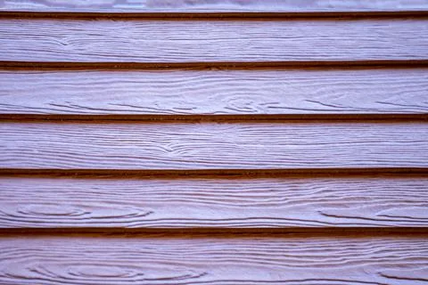 Red house wall overlapping stack of wood Foto stock