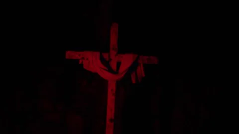 Red illuminated cross in darkness slow push eerie mood Stock Footage 332055002