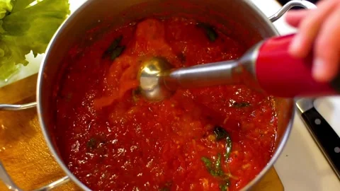 Red immersion blender mixing thick tomato sauce Vídeo Stock 333874349