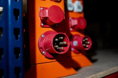 Red industrial electrical sockets mounted on orange Stock Photos