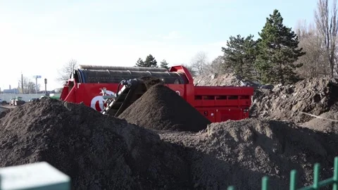 Red industrial machine sorts soil and debris on a construction site creating  Stock Footage 321650833