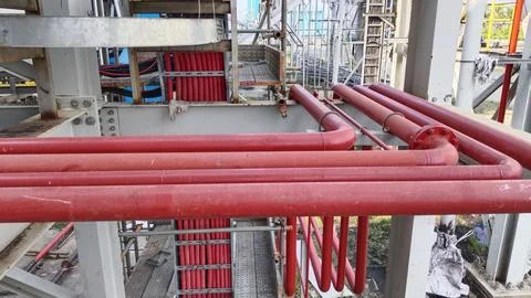 Red Industrial Pipes in Structural Framework Stock Photos