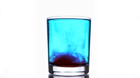 Red ink drops fall into a glass with light blue water. Stock Footage 159483326