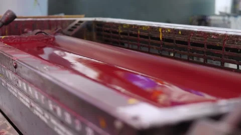 Red ink rollers inside offset printing press spreading vivid pigment Stock Footage 321540013