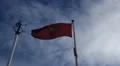 Red Isle of Man flag waving in the wind, manx, blue sky with white clouds HD Footage