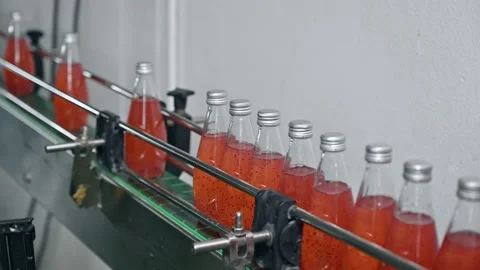 Red juice bottle sliding in automatic production line at bottling factory Video stock 185539230