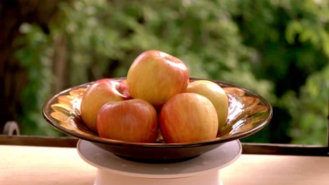 Red, juicy apples are placed in a large plate. The plate rotates against the Stock Footage 132015002