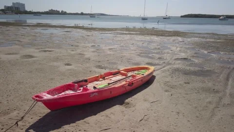 Red Kayak Boat on Beach at Maximo Park in St. Petersburg, FL  Right to left pan. Stock Footage 254830449