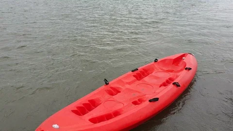 Red kayak boat float on brown water Stock Footage 114854701