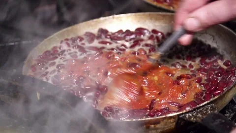 Red kidney beans frying in red sauce in pan, mixing Stock Footage 74086568