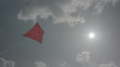 Red kite flying into the sky with clouds while swinging around | LOG Stock Footage 125194976