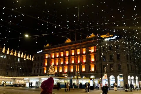 Red knitted hat in foreground at Paradeplatz at christmastime at night with b Stock Photos