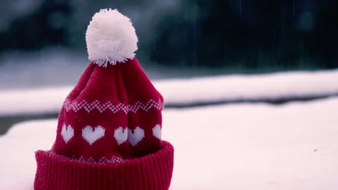 Red knitted winter hat in the snow Video stock 268809396