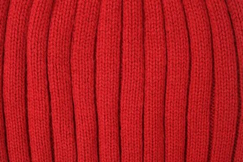 Red knitted wool fabric texture. Soft ribbed pattern of a sweater or scarf. C Stock Photos