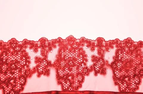 Red lace with an openwork pattern on a white background. Finishing element of Stock Photos
