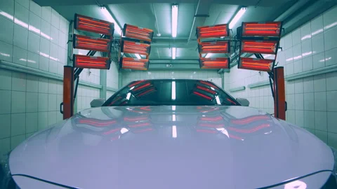 Red lamps for drying the ceramic coating are behind car. Stock Footage 100072013