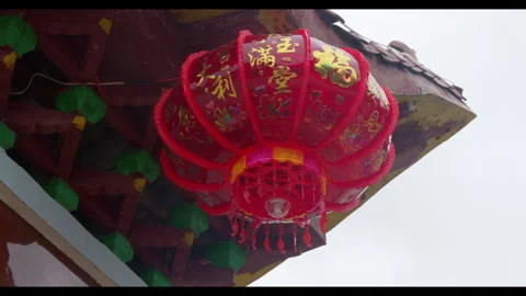 Red lantern hanging under traditional roof, no people Stock Footage 329765565