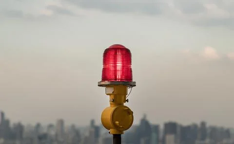 Red lantern of obstruction lights mounted on the rooftop of high rise tall bu Stock Photos