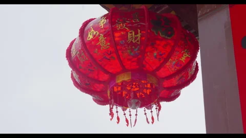 Red lantern swaying in wind under traditional roof, no people Stock Footage 329766306