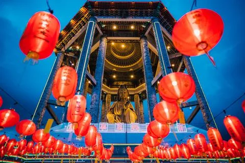 Red lanterns and a clock tower are lit up in the dark 스톡 사진