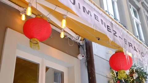 Red lanterns and glowing string lights hang Stock Footage 329242199