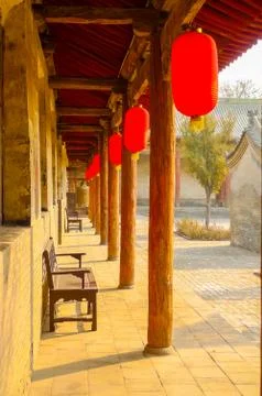Red lanterns hung under a long wooden porch Foto stock